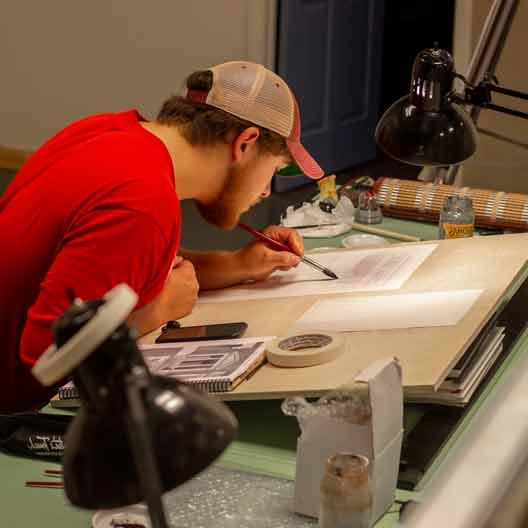 A student works at a drafting table